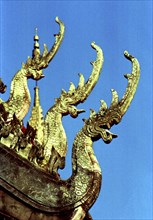 LAOS, Savannakhet, Wat Sainyamungkhun. Golden roof detail of Guardians in the form of dragons used