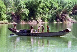 VIETNAM, Central, Hue, Fishermen on boat spearing for shell fish