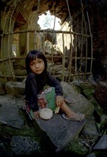 CAMBODIA, Seim Reap, Girl sitting at Banteay Srei or The Citadel of the Women where children act as