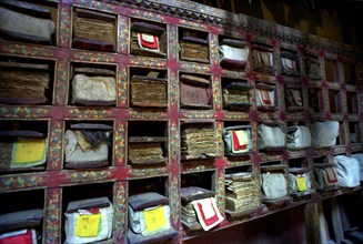 INDIA, Ladakh, Tikse, Scriptures on shelves with each pocket holding a chapter at Tikse Gompa