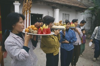 VIETNAM, Religion, Buddhism, Women with offerings at village festival near Hanoi.