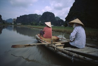 VIETNAM, North, Hoa Lu, Two women rowing bamboo canoe.