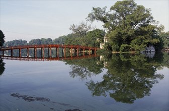 VIETNAM, North, Hanoi, The Huc or Rising Sun bridge and trees reflected in Hoan Kiem Lake.
