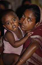 BANGLADESH, Kamalganj, Portrait of young woman holding child.