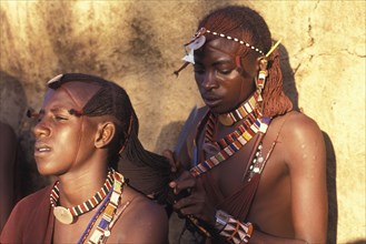 KENYA, , Maasai Moran platt each others hair prior to an initiation ceremony that will take them