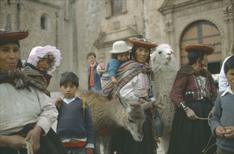PERU, Cuzco, Quechua women and children with lamas.