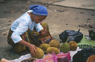 BORNEO, Sabah, Kota Belud, Dayak woman inspecting jack fruit at Tamu or open air market.