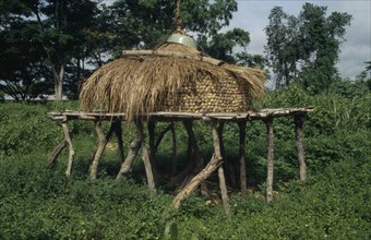 GHANA, Eastern Region, Maize store on raised platform with straw lid