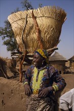 BURKINA FASO, Bisaland, Sigue Voisin Village, Girl standing below Grain store raised on stilts made