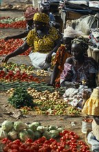 GAMBIA, Banjul, Female vendors with displays of vegetables and chillies at the market