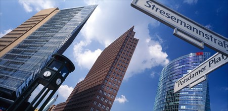 GERMANY, Berlin, Angled view of the city skyscrapers and clock with a sign post for Potsdamer Platz
