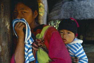 THAILAND, Chiang Rai Province, Tribal People, Lisu woman carrying her child in sling on her back.