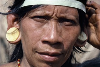 ECUADOR, Amazon, People, Portrait of a Waorani Indian woman wearing balsa ear plugs.