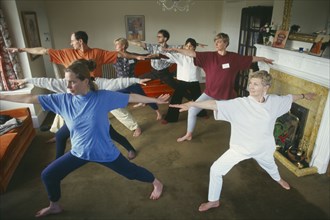 HEALTH, Exercise, Yoga, Group of men and women doing Hatha Yoga in a living room