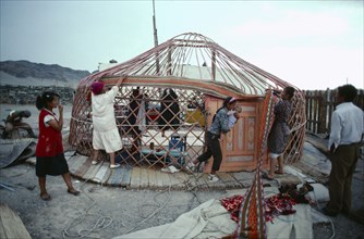 MONGOLIA, Nomadic People, Women erecting framework for a yurt.