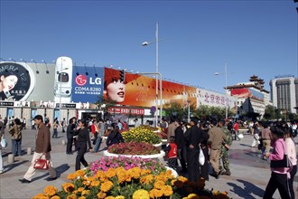 CHINA, Beijing, Busy commercial shopping area with flower pots in the foreground