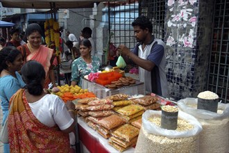 MALAYSIA, Kuala Lumpur, Brightly coloured food stall outside an Indian Temple