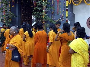 SINGAPORE, , Women dressed in orange queue at an Indian Temple