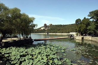 CHINA, Beijing, Summer Palace, View over water toward the complex buildings visible through trees