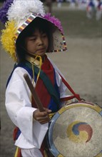 SOUTH KOREA, Seoul, Little girl in costume playing drum painted with Taegukki symbol during