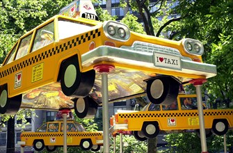 USA, New York State, New York City, Madison Square Park and Flat Iron Building. Taxi cab sculptures