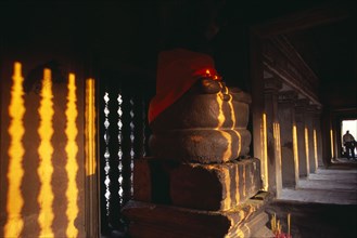 CAMBODIA, Siem Reap, Angkor Wat, Buddha statue in gallery on the third level at sunset