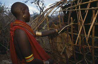 KENYA, Kenyan Highlands, Tribal People, Samburu woman building a traditional house near Maralal.