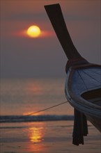 THAILAND, Krabi, Koh Lanta Yai, Klong Dao beach at sunset with the bow of a fishing boat pointing