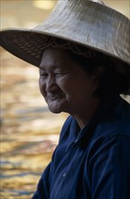 THAILAND, South, Bangkok, Damnoen Saduak Floating Market portrait of an old female vendor wearing a