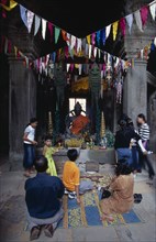 CAMBODIA, Siem Reap Province, Angkor, Banteay Kdei.  Cambodian visitors lighting incense at shrine