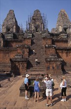 CAMBODIA, Siem Reap Province, Angkor, Preah Rup.  Western tourists with guide at cremation pit in