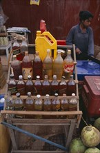 CAMBODIA, Siem Reap, Roadside stall selling bottles of petrol watered down and at the same price as