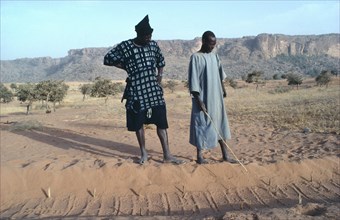 MALI, Dogon, A Diviner and Dogon client explains marks left in sand by desert fox over the marks he
