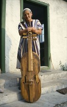 ROMANIA, Transylvania, Gimes Village, "Elderly woman with a gardon, a traditional cello like