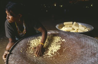 COLOMBIA, Amazonas, Santa Isabel, Macuna woman sieving manioc that has previously been grated