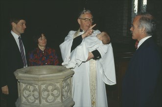 ENGLAND, Yorkshire, Religion, Church of England baptism.  Priest makes sign of the cross on the
