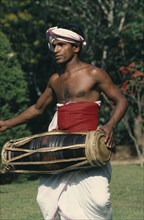 SRI LANKA, Kandy, Perahera Buddhist festival.  Traditional drummer.