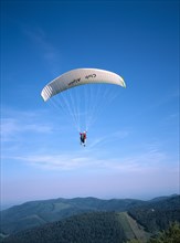 FRANCE, Alsace, Haut Rhin, Paraglider decending from Ballon de l Alsace