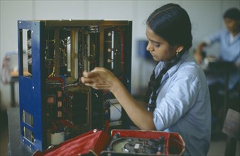 INDIA, Maharashtra, Bombay, Woman working in electronics factory.