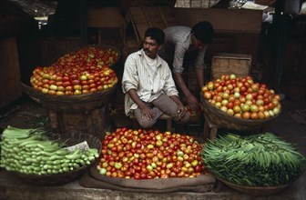 INDIA, Karnataka, Mysore, "Vendor at roadside stall selling okra, tomatoes and aubergines."