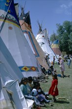 CANADA, Alberta, Calgary, Colourful Native North American Indian Tepees with people gathered on