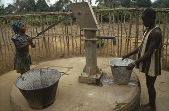 SIERRA LEONE, Kambia, Young women using hand water pump.