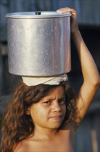BRAZIL, Tribal People, Young girl carrying pot of water on her head.