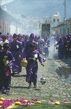 GUATEMALA, Antigua, Men and boys wearing traditional purple robes and burning incense in censers
