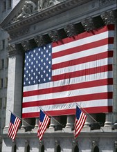 USA, New York, Manhattan, Wall Street stock exchange with stars and stripes flag draped across the