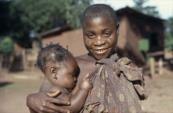 CENTRAL AFRICAN REPUBLIC, Tribal People, Portrait of Pygmy woman holding young child.