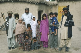 PAKISTAN, Family, Family portrait of Baluchi men and children.  Modesty prevents the wives from