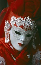 ITALY, Veneto, Venice, Venice Carnevale. Portrait of a masked figure in a red costume