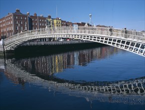 IRELAND, Dublin, Halfpenny Bridge spanning the River Liffey reflected in the water.