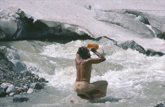 INDIA, Uttar Pradesh, Garhwal Region, Pilgrim bathing at Gormuich or the Cows Mouth source of the
